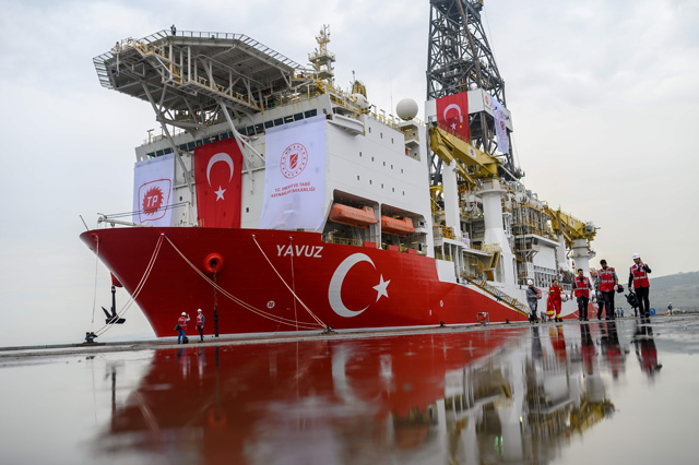 In this file photo taken on June 20 journalists walk next to the drilling ship 'Yavuz' scheduled to search for oil and gas off Cyprus, at the port of Dilovasi, outside Istanbul (AFP photo)