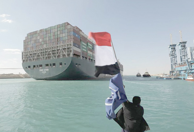 A photo released by Egypt's Suez Canal Authority on Monday, shows a man waving the Egyptian flag after Panama-flagged MV 'Ever Given' container ship was fully dislodged from the banks of the Suez (AFP photo)