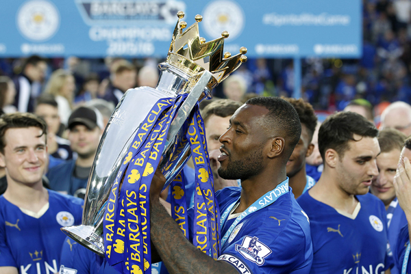 Leicester City’s Wes Morgan with the trophy on Saturday as they celebrate winning the English Premier League at the King Power Stadium in Leicester, England, on Saturday (Reuters photo by John Clifton)