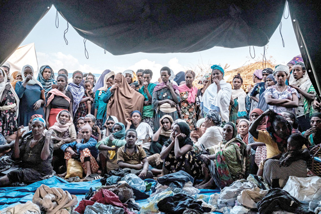 In this file photograph taken on January 26, Internally Displaced People, fleeing from violence in the Metekel zone in Western Ethiopia, gather outside a tent where clothes are being distributed at a camp in Chagni, Ethiopia (AFP photo)