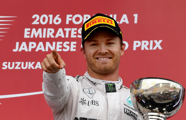 Mercedes AMG Petronas F1 Team’s German driver Nico Rosberg holds the cup as he celebrates winning first place on the podium after the Formula One Japanese Grand Prix race in Suzuka on Sunday  (AFP photo by Toshifumi Kitamura)