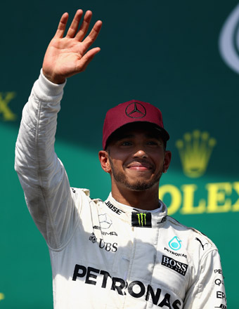 Race winner Lewis Hamilton of Great Britain waves to the crowd on the podium after winning the Canadian Formula One Grand Prix in Montreal, Canada, on Sunday  (AFP photo by Clive Mason)