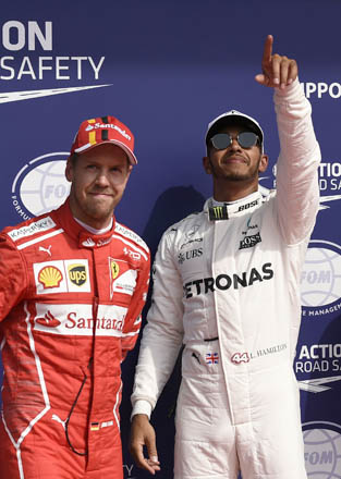 Mercedes’ British driver Lewis Hamilton (right) celebrates winning the pole position next to second placed Ferrari’s German driver Sebastian Vettel after the qualifying session at the Spa-Francorchamps circuit in Spa on Saturday ahead of the Belgian Formula One Grand Prix (AFP photo by John Thys)
