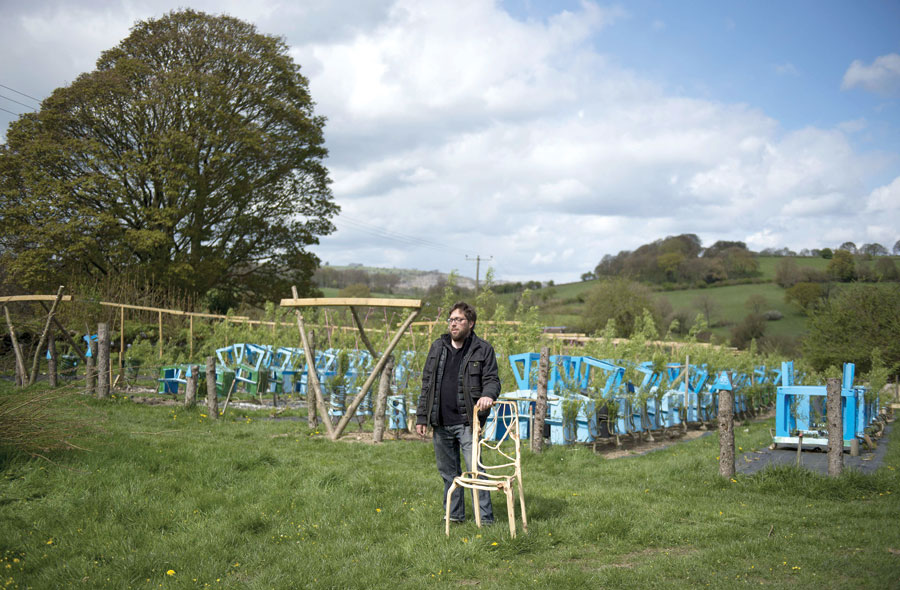 Artist and furniture maker Gavin Munro stands with an early prototype chair in front of trees growing around their specially constructed frames to produce items of furniture at his ‘Full Grown’ plantation site near Wirksworth, central England, on April 28 (AFP photo by Oli Scarff)