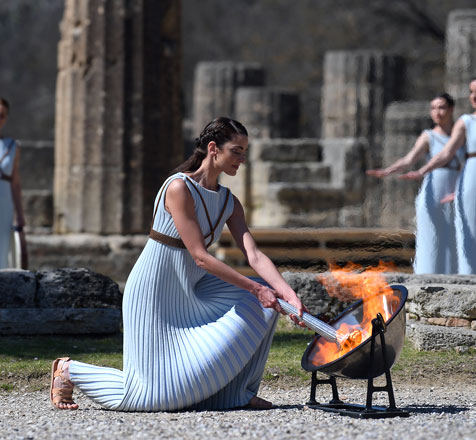 Woman dressed as a priestess lights the Olympic flame during the Olympic ceremony in ancient Olympia, Greece, on Thursday (AFP photo by Aris Messinis)