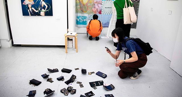 Visitors look at the artworks during the opening ceremony of a stealable art exhibition (AFP photo)