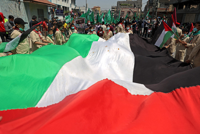 Palestinian protesters wave national (foreground) and Hamas movement flags during a demonstration in the Jabalia refugee camp in the Gaza Strip on April 30, following the postponement of the upcoming Palestinian elections which were supposed to take place next month (AFP photo)