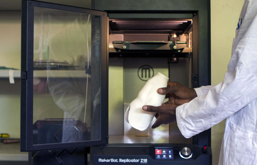 Orthopaedic technology specialist Moses Kaweesa works on a 3D-printed artificial limb at the Comprehensive Rehabilitation Services in Uganda (AFP photo by Isaac Kasamani)