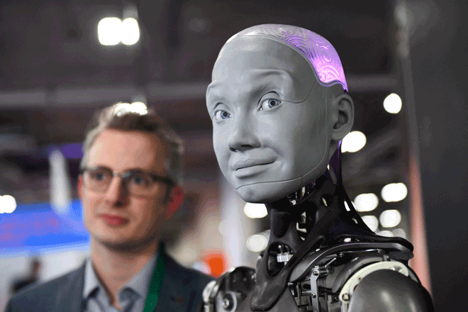 Morgan Roe, director of operations at Engineered Arts, speaks about the Engineered Arts Ameca humanoid robot with artificial intelligence as it is demonstrated during the Consumer Electronics Show (CES) in Las Vegas, Nevada, on January 5, 2022 (AFP photo by Patrick T. Fallon)