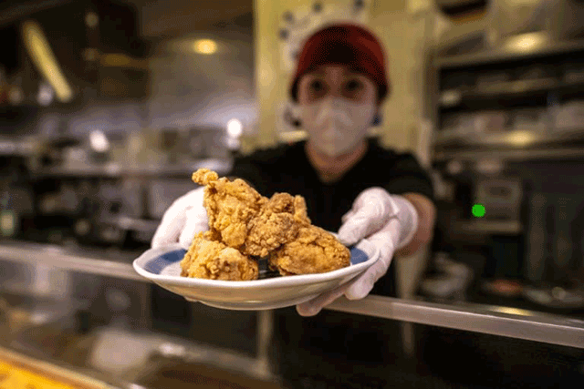 Hiromi Matsumoto serves a plate of karaage, a Japanese style fried chicken, at an izakaya food store in Tokyo on March 1 (AFP photo by Philip Fong)