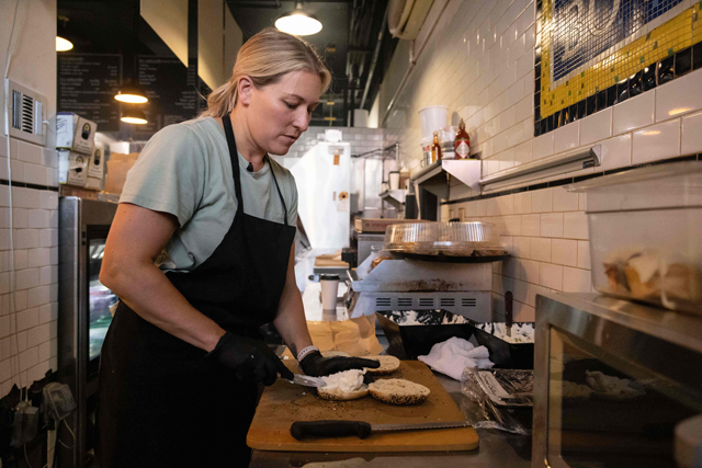 Ashley Dikos, wife of Bo’s Bagels owner Andrew Martinez, spreads bagels with cream cheese at Bo’s Bagels in New York City, on July 12 (AFP photo by Yuki Iwamura)