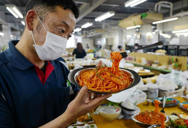 A fork stands suspended in mid-air, strands of ‘spaghetti’ dangling, as factory head Hiroaki Miyazawa checks a finished plastic food sample (AFP photo by Kazuhiro Nogi)