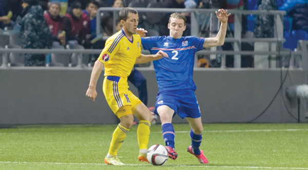 Iceland player (left) takes on Kazakhstan player at home on Sunday during their UEFA Euro 2016 qualifying round match (Photo courtesy of kff.kz )