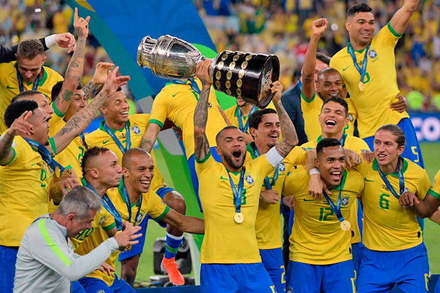 Brazil’s Dani Alves (centre) and teammates celebrate with the trophy after winning the Copa America after defeating Peru in the final match of the football tournament in Rio de Janeiro, Brazil, on Sunday (AFP photo by Juan Mabromata)