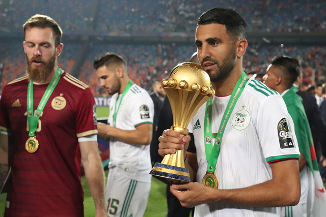Algeria’s forward Riyad Mahrez (right) celebrates with the trophy of the 2019 Africa Cup of Nations after beating Senegal in Cairo on Friday  (AFP photo by Khaled Desouki)