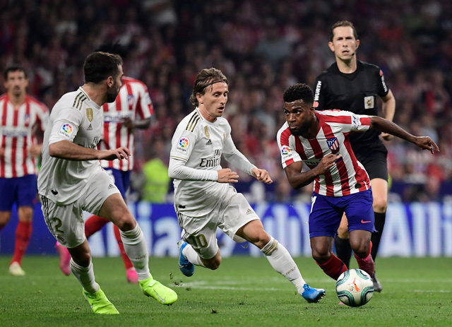 Atletico Madrid’s midfielder Thomas Lemar (right) vies with Real Madrid’s midfielder Luka Modric (centre) during their Spanish league football match in Madrid on Saturday (AFP photo by Javier Soriano)