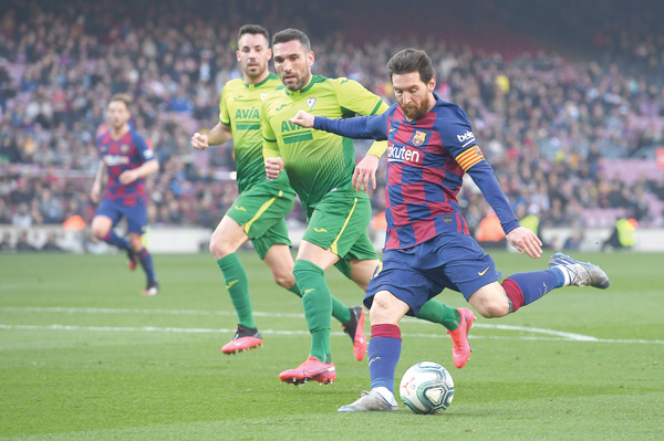 Barcelona’s Argentine forward Lionel Messi (right) kicks the ball against Eibar during their Spanish league football match in Barcelona on Saturday (AFP photo by Josep Lago)
