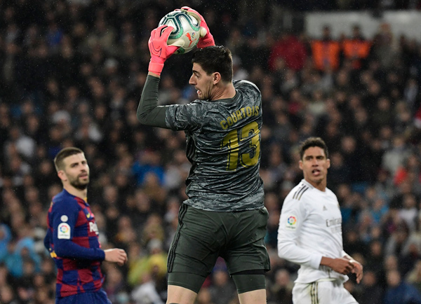 Real Madrid’s Belgian goalkeeper Thibaut Courtois makes a save during their Spanish League football match against Barcelona in Madrid on Sunday  (AFP photo by Javier Soriano)