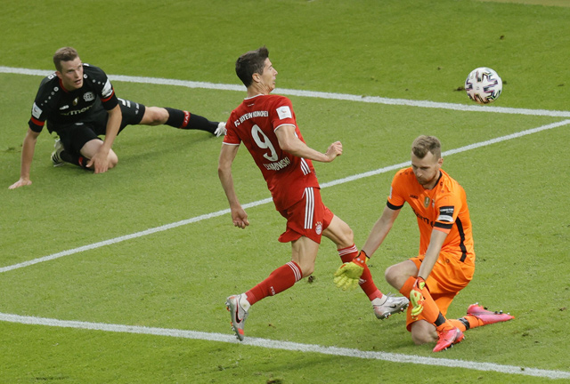 Bayern Munich’s Polish forward Robert Lewandowski scores past Leverkusen’s Finnish goalkeeper Lukas Hradecky during their German Cup final match in Berlin on Saturday  (AFP photo by Ronald Wittek)