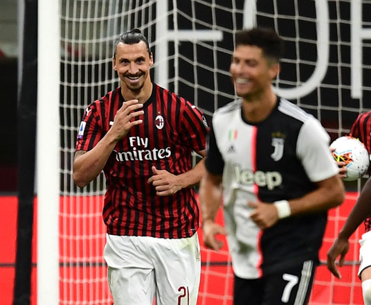 AC Milan’s forward Zlatan Ibrahimovic reacts next to Juventus’ forward Cristiano Ronaldo (right) after scoring a penalty during their Italian (Serie A) match in Milan on Tuesday (AFP photo by Miguel Medina)