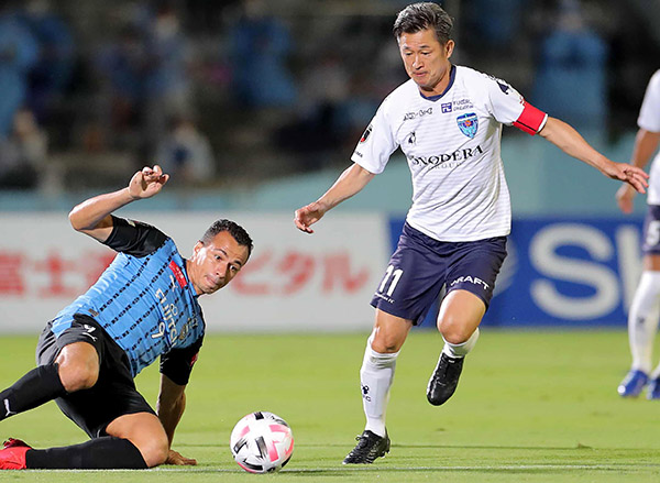 Yokohama FC forward Kazuyoshi Miura (right) is tackled by Kawasaki Frontale forward Leandro Damiao during their J-League football match in Kawasaki on Wednesday  (AFP photo)