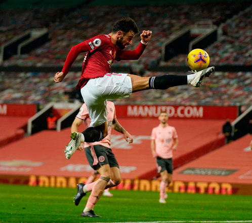 Manchester United’s Portuguese midfielder Bruno Fernandes leaps to volley a cross against Sheffield United during their English Premier League match in Manchester on Wednesday (AFP photo by Tim Keeton)