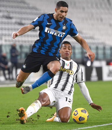Juventus’ Brazilian defender Alex Sandro (rear) tackles Inter Milan’s Moroccan defender Achraf Hakimi at the limit of the penalty area during their Italian Cup semifinal match in Turin on Tuesday (AFP photo by Marco Bertorello)