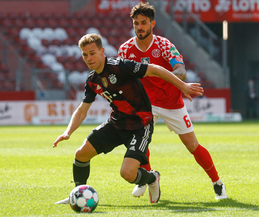 Bayern Munich’s midfielder Joshua Kimmich (left) and Mainz’ midfielder Danny Latza vie for the ball during their German first division Bundesliga match in Mainz on Saturday  (AFP photo by Kai Pfaffenbach)