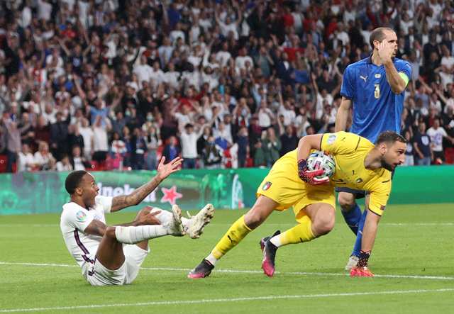 Italy’s goalkeeper Gianluigi Donnarumma (centre) saves a shot from England’s forward Raheem Sterling (left) during their UEFA Euro 2020 final match in London on Sunday  (AFP photo by Carl Recine)