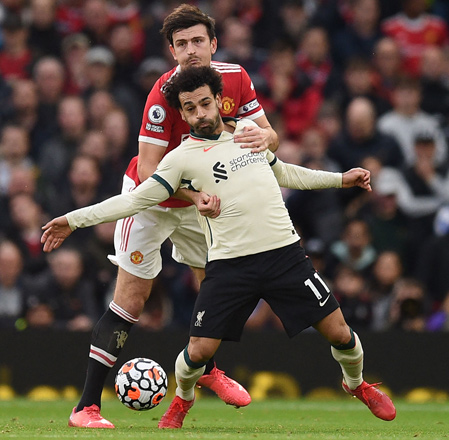 Liverpool’s midfielder Mohamed Salah vies with Manchester United’s defender Harry Maguire (right) during their English Premier League match in Manchester on Sunday (AFP photo by Oli Scarff)