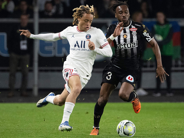 Paris Saint-Germain’s midfielder Xavi Simons (left) fights for the ball with Angers’ defender Souleyman Doumbia during their French L1 match in Angers on Wednesday  (AFP photo by Loic Venance)