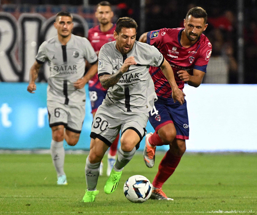 Paris Saint-Germain’s Lionel Messi fights for the ball with Clermont-Ferrand’s Mateusz Wieteska (right) during their French L1 match in Clermont-Ferrand, France, on Saturday (AFP photo by Jean-Philippe Ksiazek)