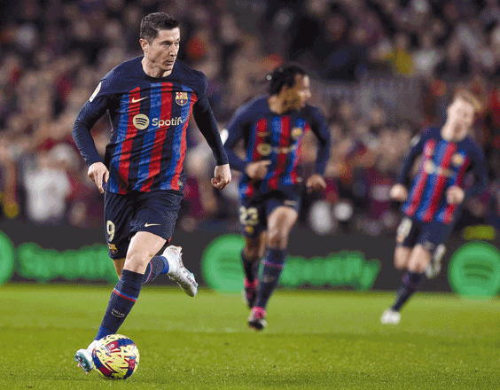 Barcelona’s Polish forward Robert Lewandowski runs with the ball against Sevilla during their Spanish league match in Barcelona on Sunday (AFP photo by Josep Lago)