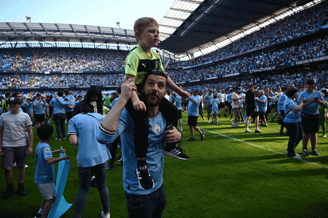 Manchester City fans invade the pitch as they celebrate winning the title after the English Premier League match between Manchester City and Chelsea in Manchester on Sunday (AFP photo by Oli Scarff)