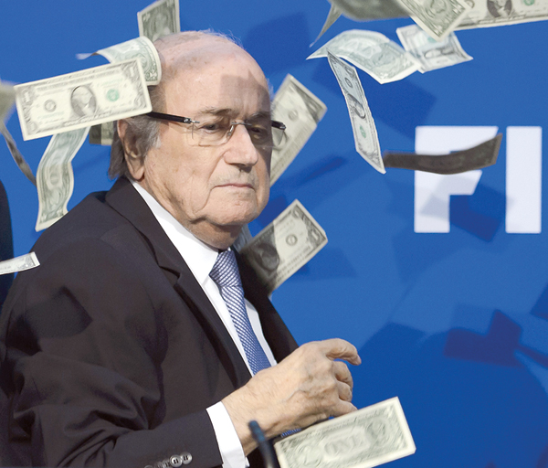 FIFA President Sepp Blatter looks on with fake dollars note flying around him thrown by a protester during a press conference at the football’s world body headquarter’s on Monday in Zurich (AFP photo by Fabrice Coffrini)