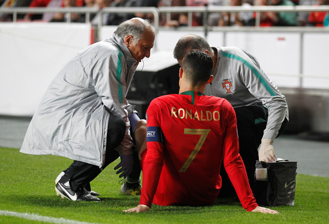 Portugal’s Cristiano Ronaldo receives treatment from medical staff during the Euro 2020 qualifier match against Serbia in Lisbon on Monday   (Reuters photo by Rafael Marchante)