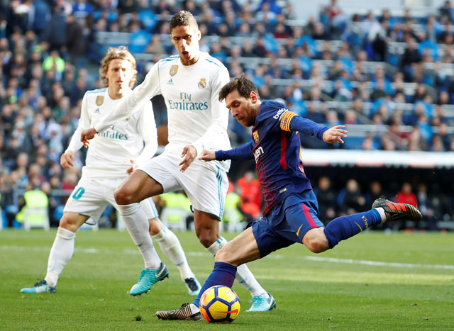 Barcelona’s Lionel Messi in action as Real Madrid’s Raphael Varane attempts to block in Madrid, Spain, on Saturday  (Reuters photo by Paul Hanna)