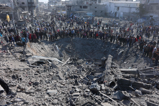 Palestinians gather around a large crater following an Israeli strike on a metalsmith workshop at the Zaytoun neighbouhood in Gaza City on April 13, 2025 (AFP photo)