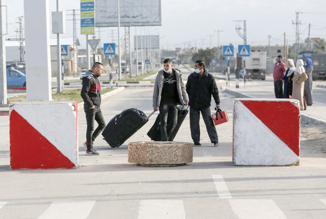 Palestinians walk with luggage at the Rafah border crossing's departure area to travel from the Gaza Strip into Egypt on Tuesday (AFP photo)
