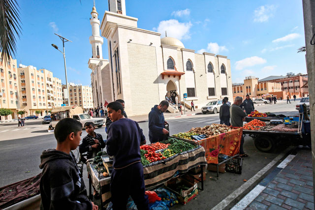 Palestinians shop for vegetables and produce from peddlars by the new Qatari-built Sheikh Hamad Bin Khalifa Al Thani Mosque in Khan Yunis, in the southern Gaza Strip, on November 20 (AFP photo)