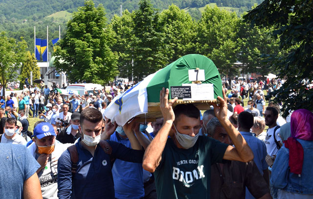Bosnian Muslim men wearing face masks carry the casket of a newly identified victim during a burial ceremony marking the 25th anniversary of the Srebrenica massacre, at the Potocari memorial cemetery, a village just outside Srebrenica on Saturday (AFP photo)