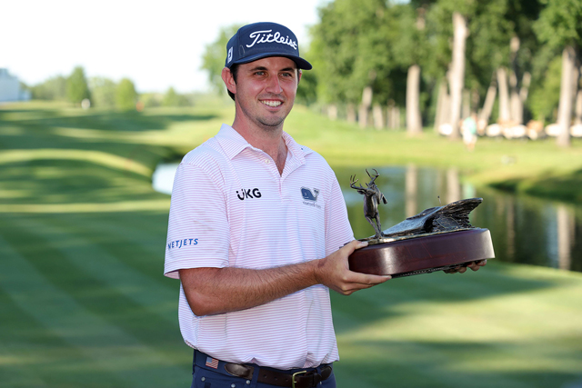 J.T. Poston of the United States poses with the trophy of the John Deere Classic at TPC Deere Run in Silvis, Illinois, on Sunday (AFP photo by Stacy Revere)