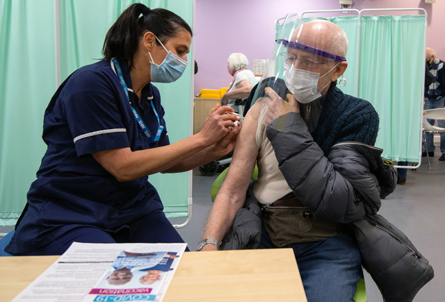 A patient receives an injection of a Covid-19 vaccine at the mass vaccination hub at Robertson House in Stevenage, north of London, on Monday (AFP photo)