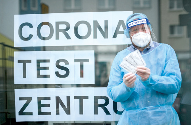 Doctor Klaus Renckhoff shows rapid antigen test kits at the COVID test centrer in a specially created room next to the 'Loewen' pharmacy in Hagen, western Germany, on Wednesday (AFP photo)
