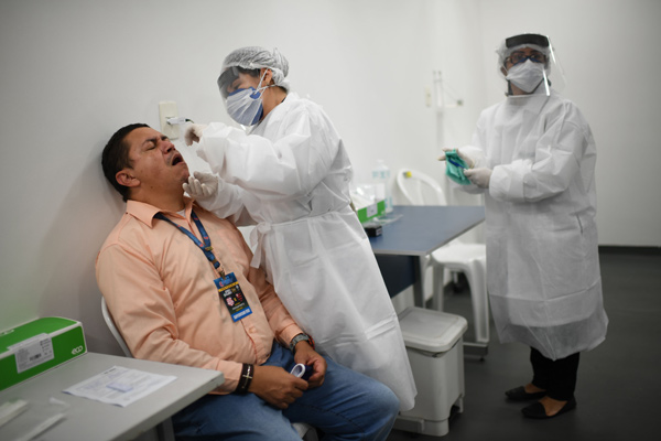 A journalist has a sample taken to be tested for COVID-19 before being allowed to work prior to a Carioca Championship 2020 football match between Flamengo and Bangu at the Maracana Stadium in Rio de Janeiro, Brazil, on Thursday (AFP photo)