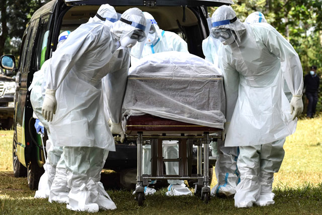 Members of Bungoma County Isolation Team carry the coffin of Dr. Doreen Lugaliki, 39, the first Kenyan doctor who died of the COVID-19 coronavirus in Nairobi, during her funeral in Ndalu, western Kenya, on Monday (AFP photo)