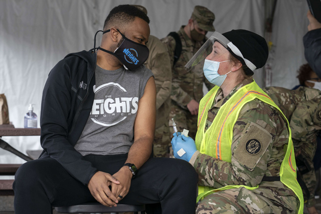 A man speaks with a member of the National Guard after receiving a coronavirus vaccine in the parking lot of Six Flags on Saturday in Bowie, Maryland (AFP photo)