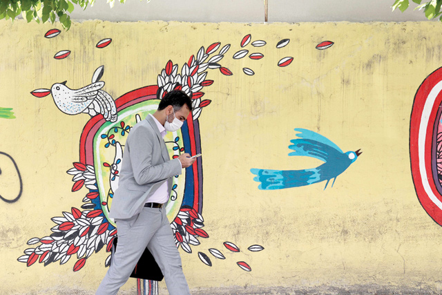 An Iranian man walks down a street in the capital Tehran, on Monday, following the tightening of restrictions to curb the surge of COVID-19 cases (AFP photo)