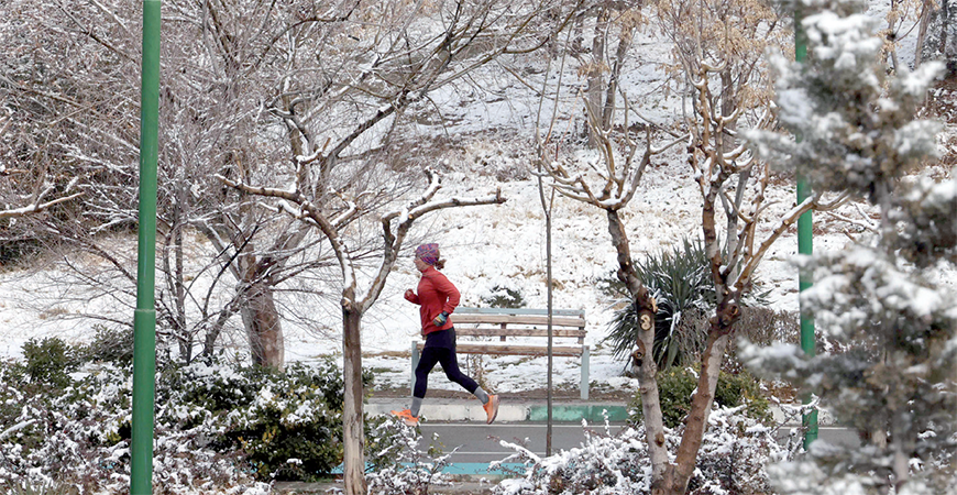 A woman jogs on a snowy day in Tehran, on Sunday (AFP photo)