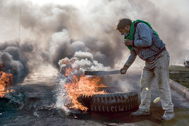 An anti-government protester cuts off a road with flaming tyres during a demonstration against the new Iraqi prime minister-designate in the central Shiite holy shrine city of Najaf on Sunday (AFP photo)